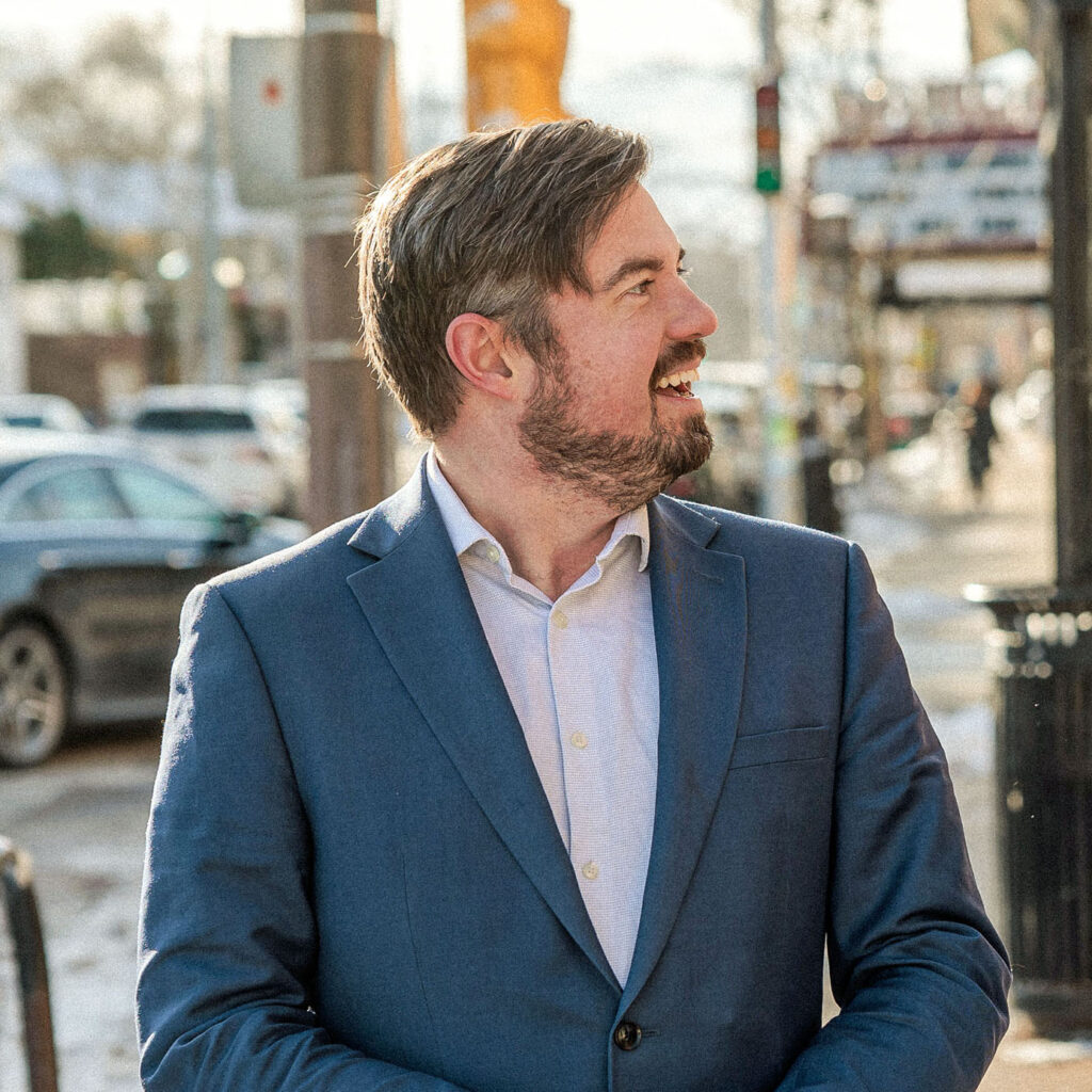 Photo of Alex Brower, candidate for Milwaukee's Common Council District 3, standing outside on Downer Avenue